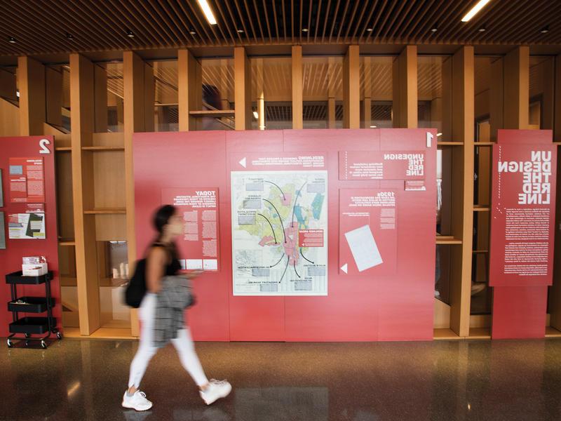 A student walks passed the "Undesign the Redline" display